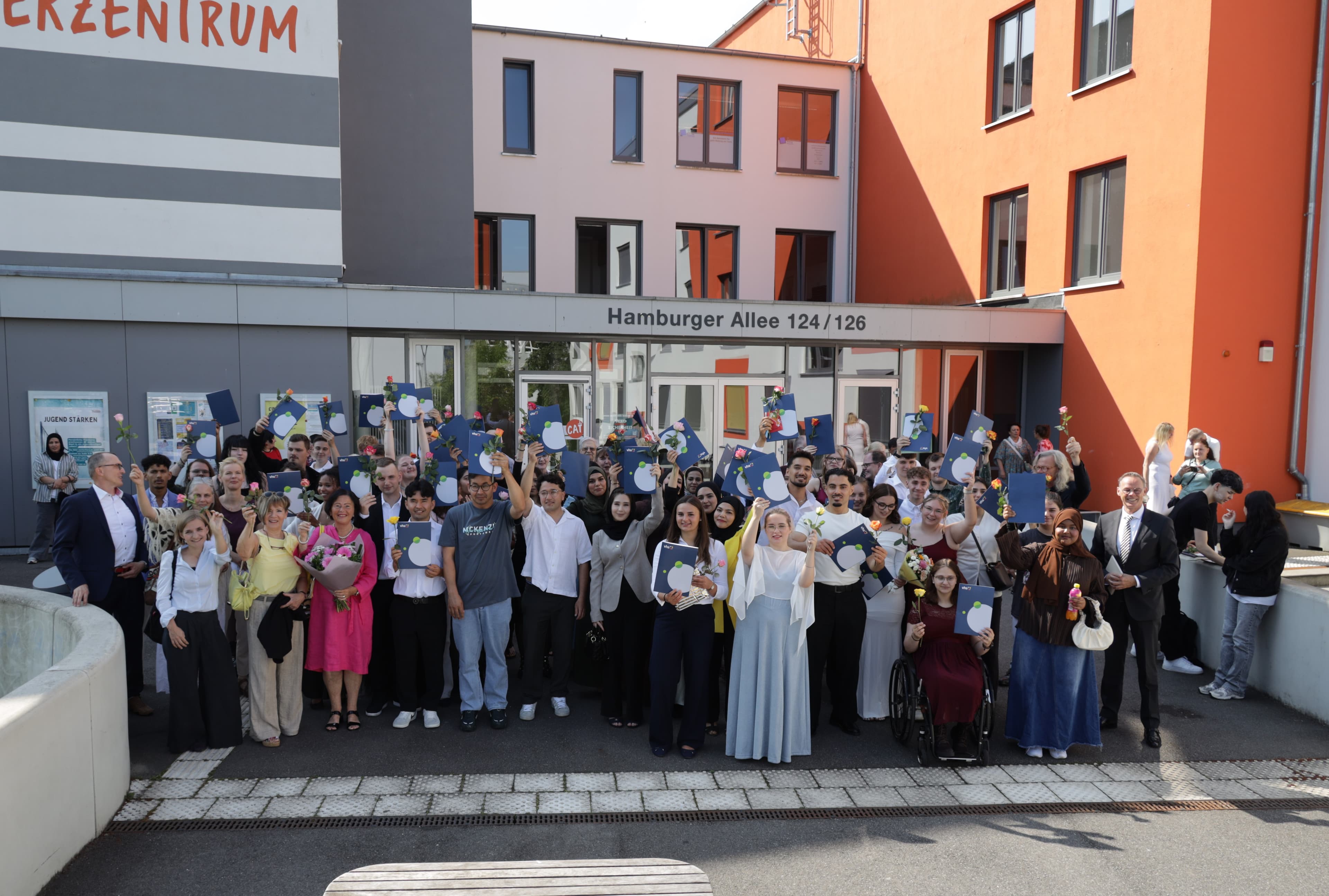 Absolventinnen und Absolventen der Volkshochschule Schwerin mit ihren Zeugnissen