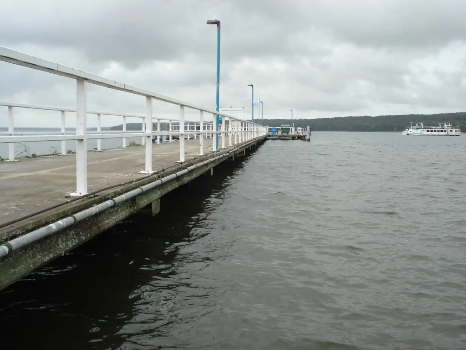 Ein Badehaussteg am Tollensesee in Neubrandenburg mit Geländer und Beleuchtung, aufgenommen bei Tageslicht.